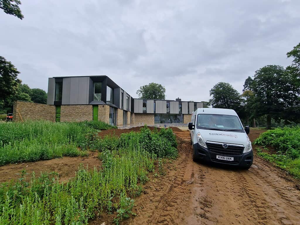 Drainage installation at modern building site by Centra Drains Ltd for flood prevention and landscape protection.
