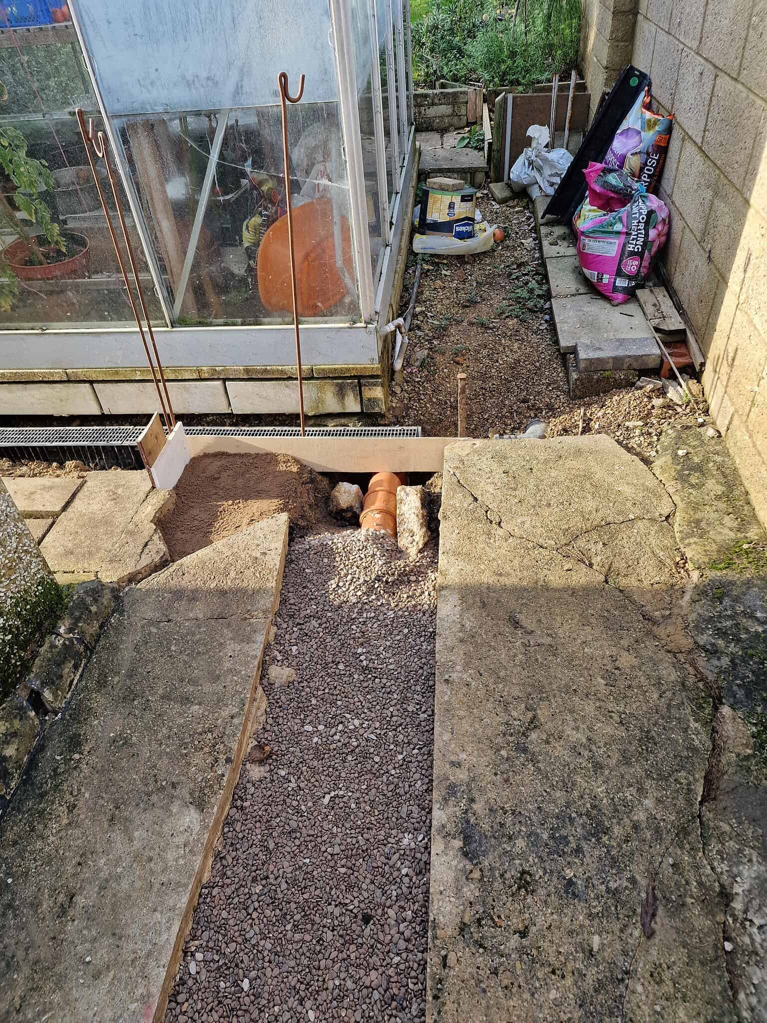 Blocked drainage pipe installation for garden drainage solutions.