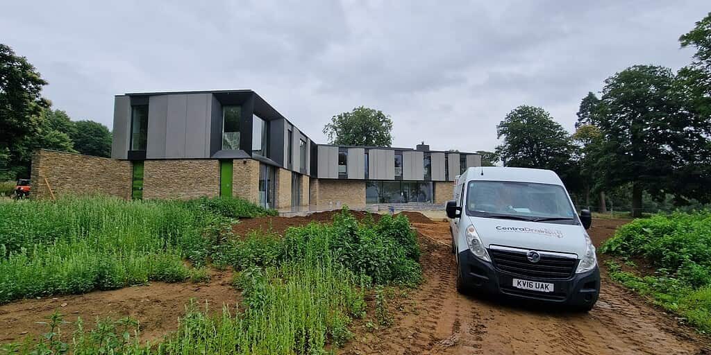 Drainage installation at modern building site by Centra Drains Ltd for flood prevention and landscape protection.