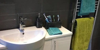 Bathroom sink with cabinet and towel rack in a modern bathroom setting.